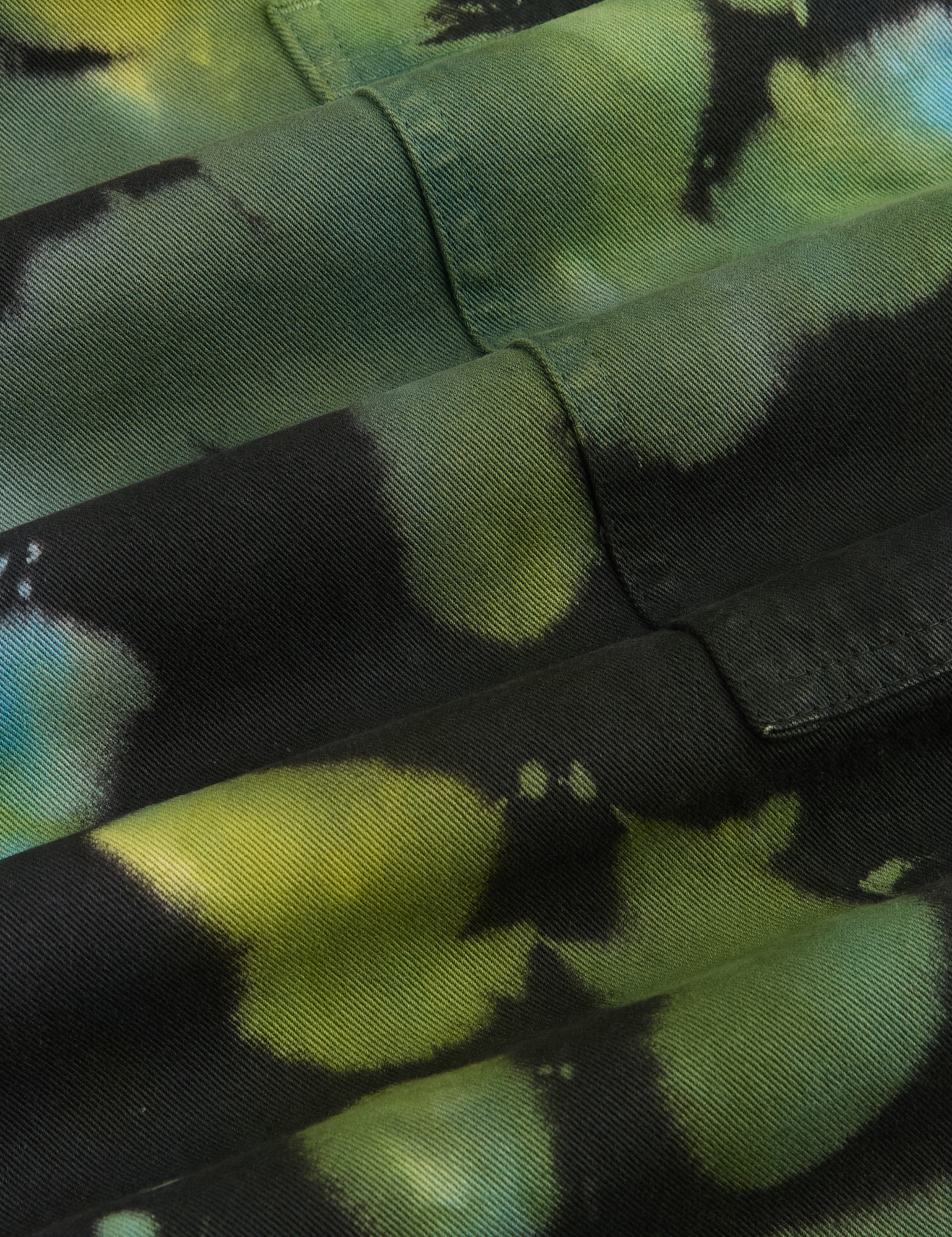 Magic Waters Drop Pocket Pants in Green Pool fabric detail close up. Tie dye in shades of green, turquoise and black
