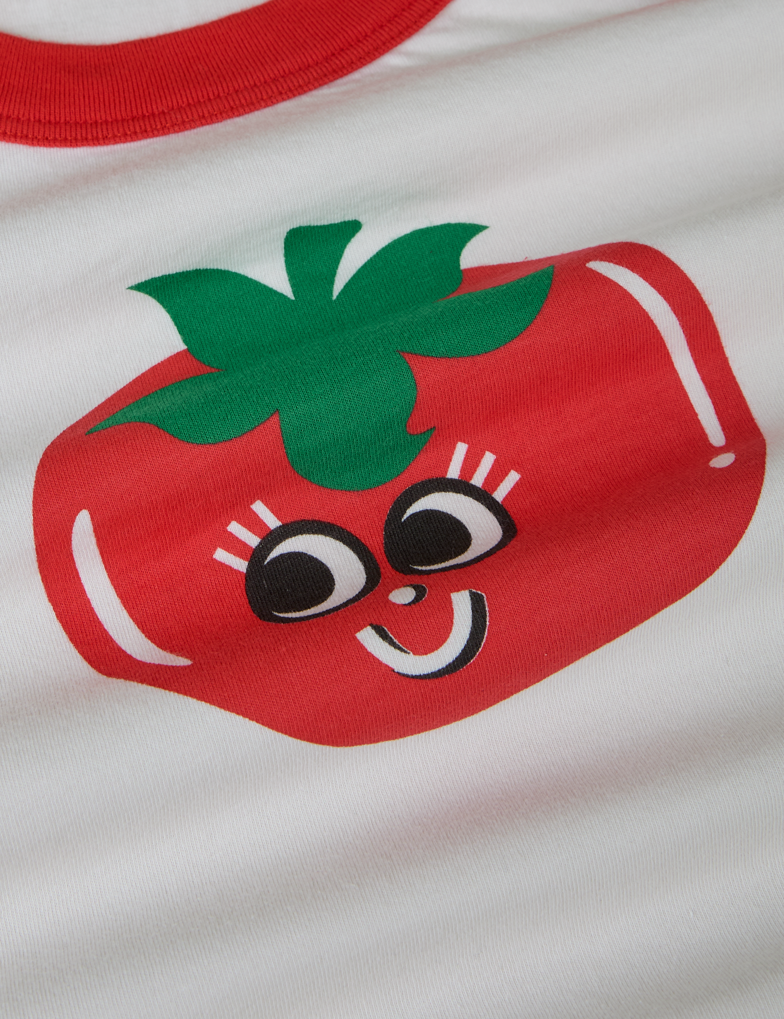 Produce Raglan Tee in Tomato close up. Illustrated tomato character with smiley face