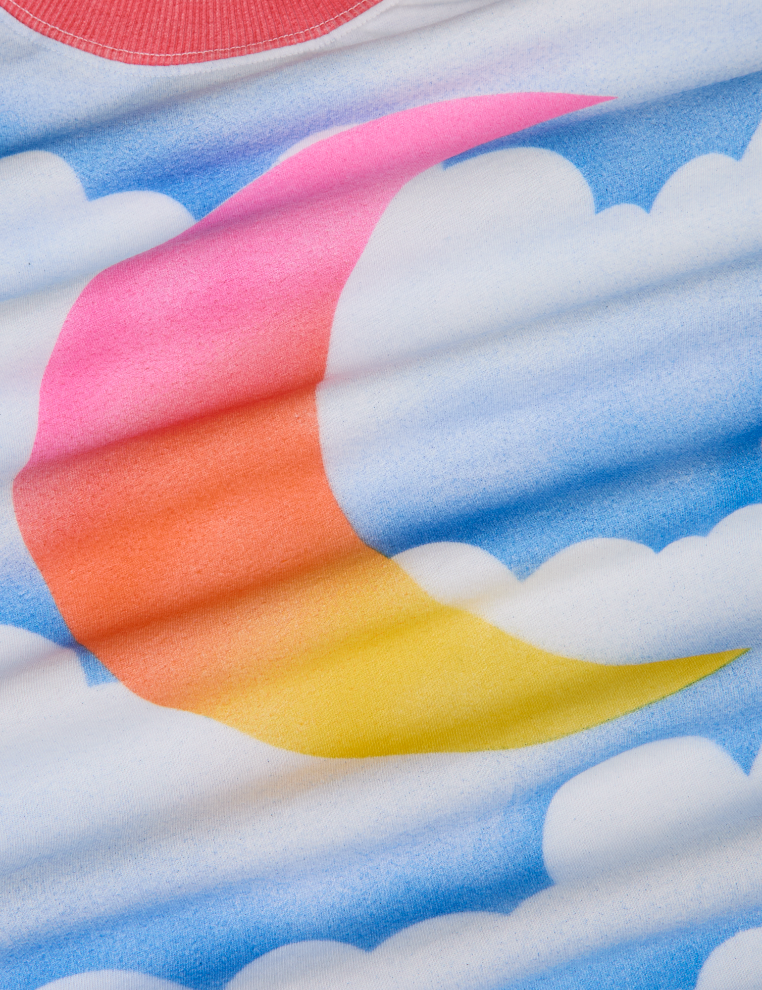 Airbrush Moon Vintage Tee fabric detail close up. Airbrush gradient moon in pink, orange and yellow. Blue skies and white clouds background