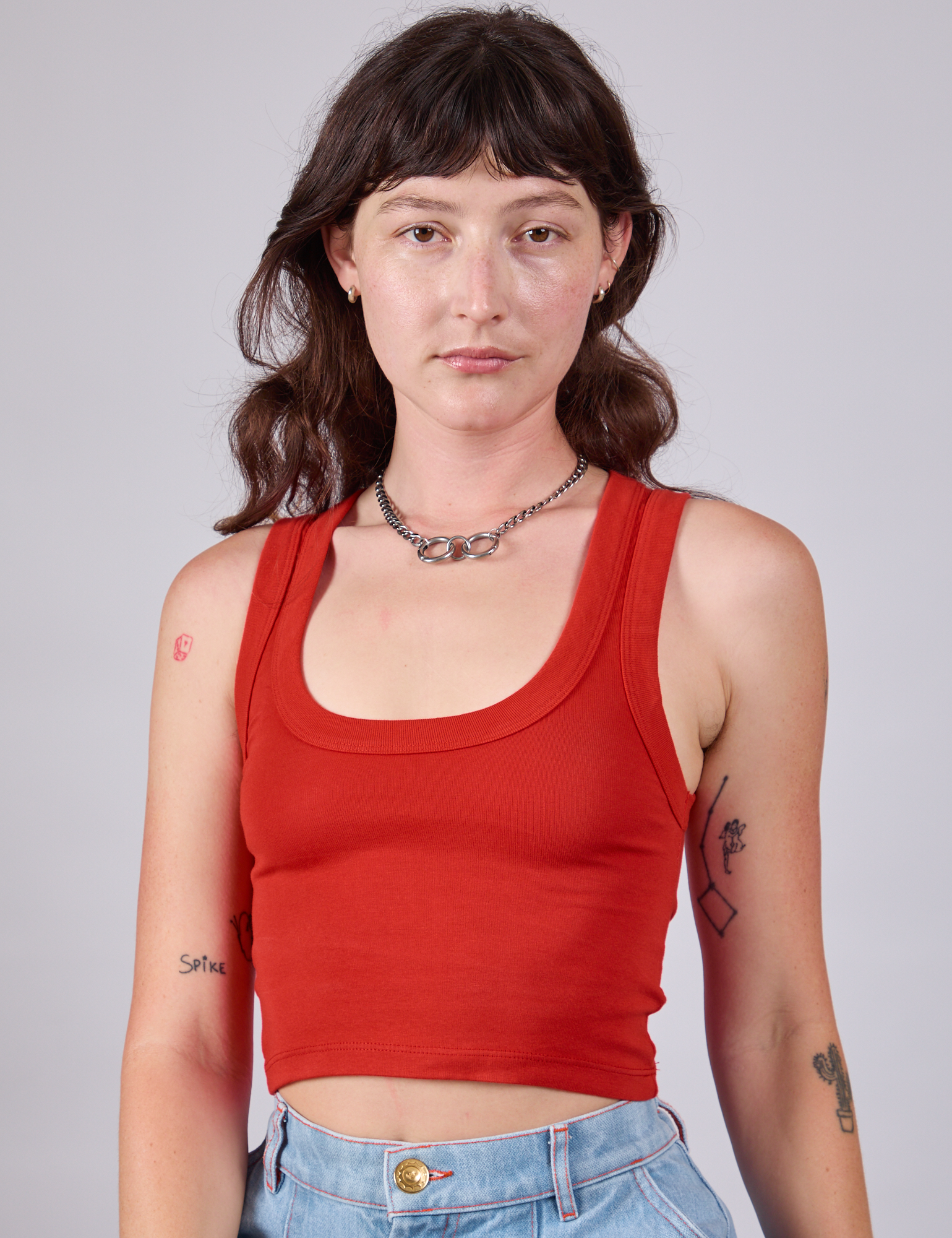 Alex is 5'8" and wearing P Cropped Tank Top in Mustang Red