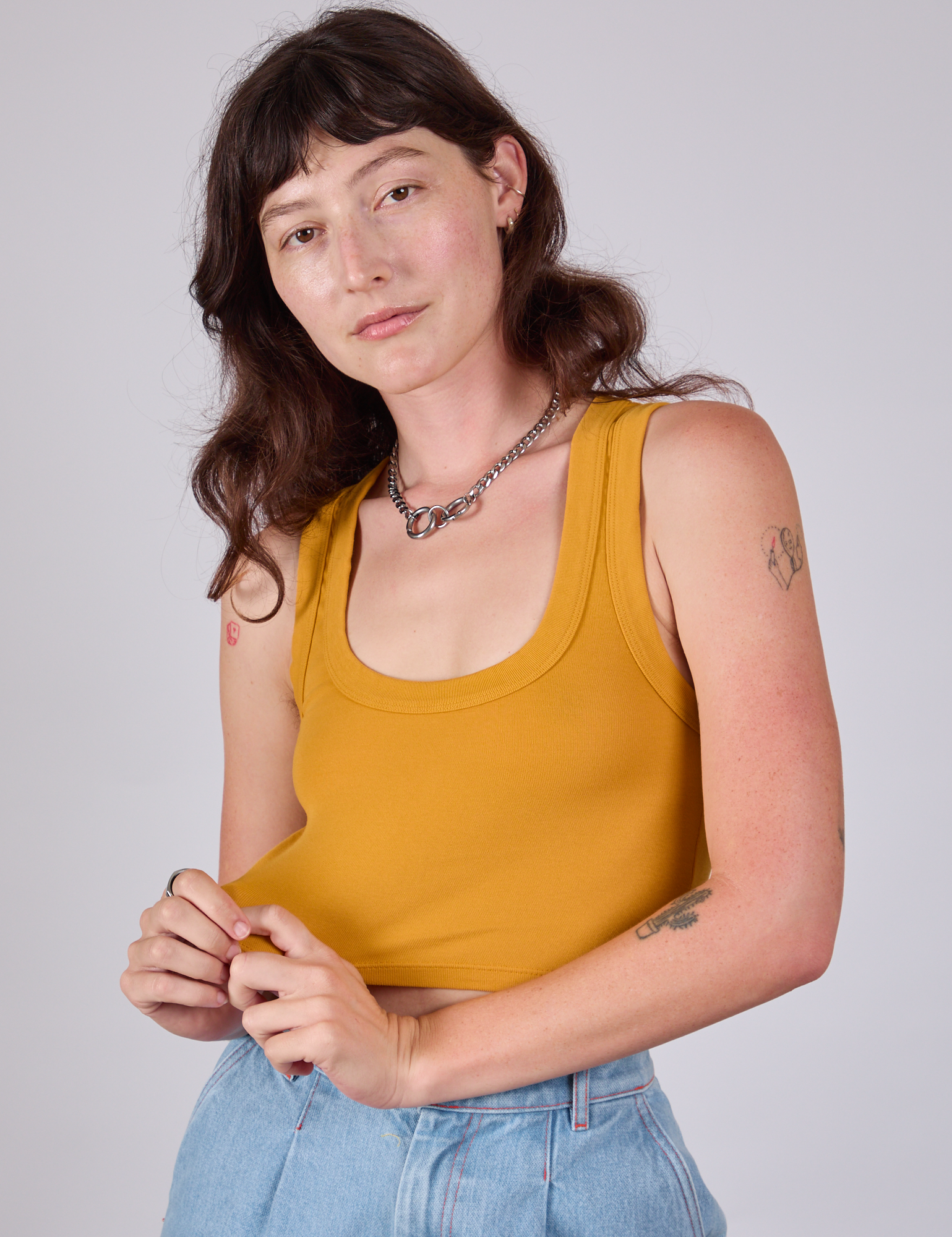 Alex is wearing Cropped Tank Top in Mustard Yellow