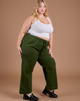 Angled front view of Organic Action Pants in Evergreen and vintage tee white Cropped Tank