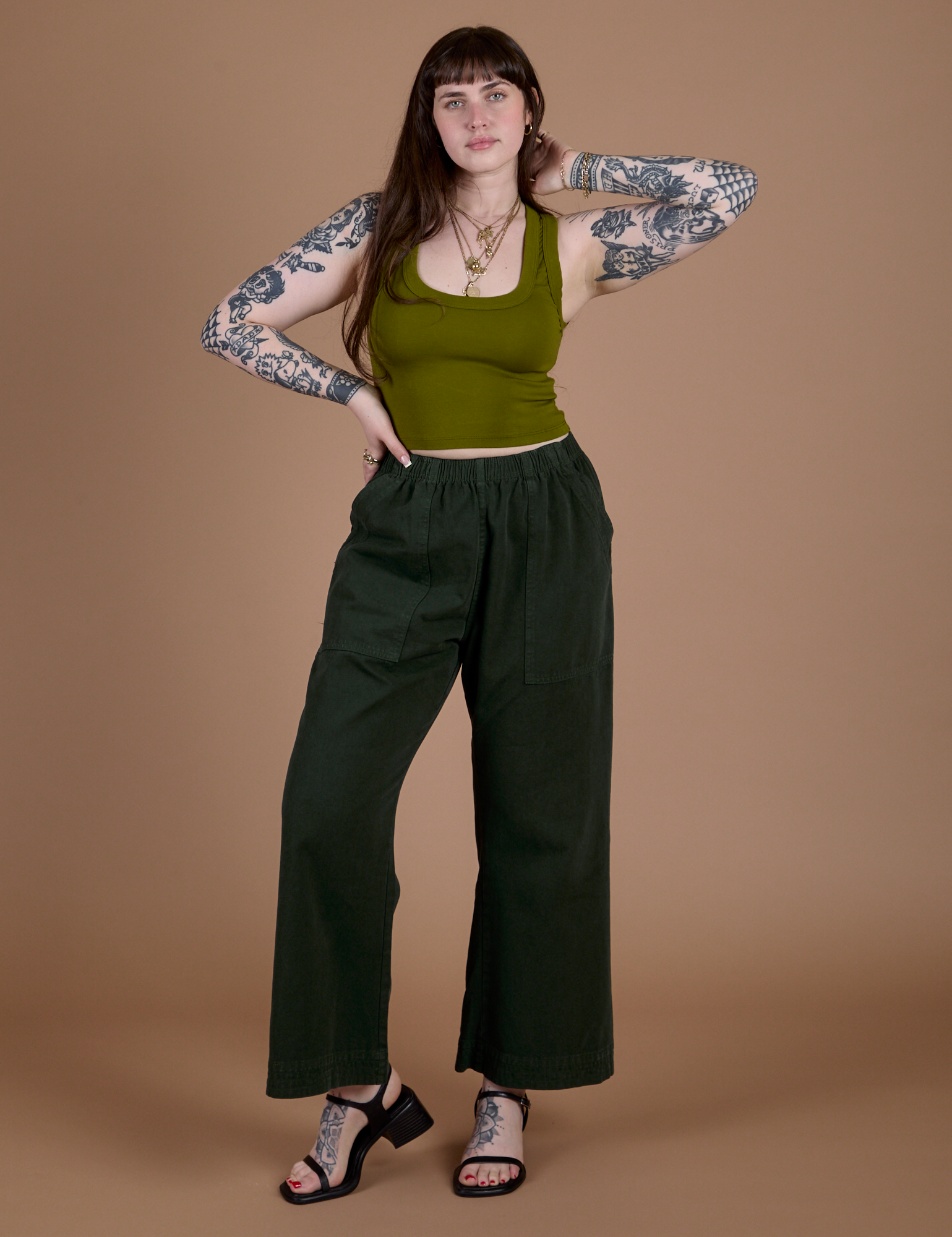 Sydney is wearing Action Pants in Swamp Green paired with olive green Cropped Tank