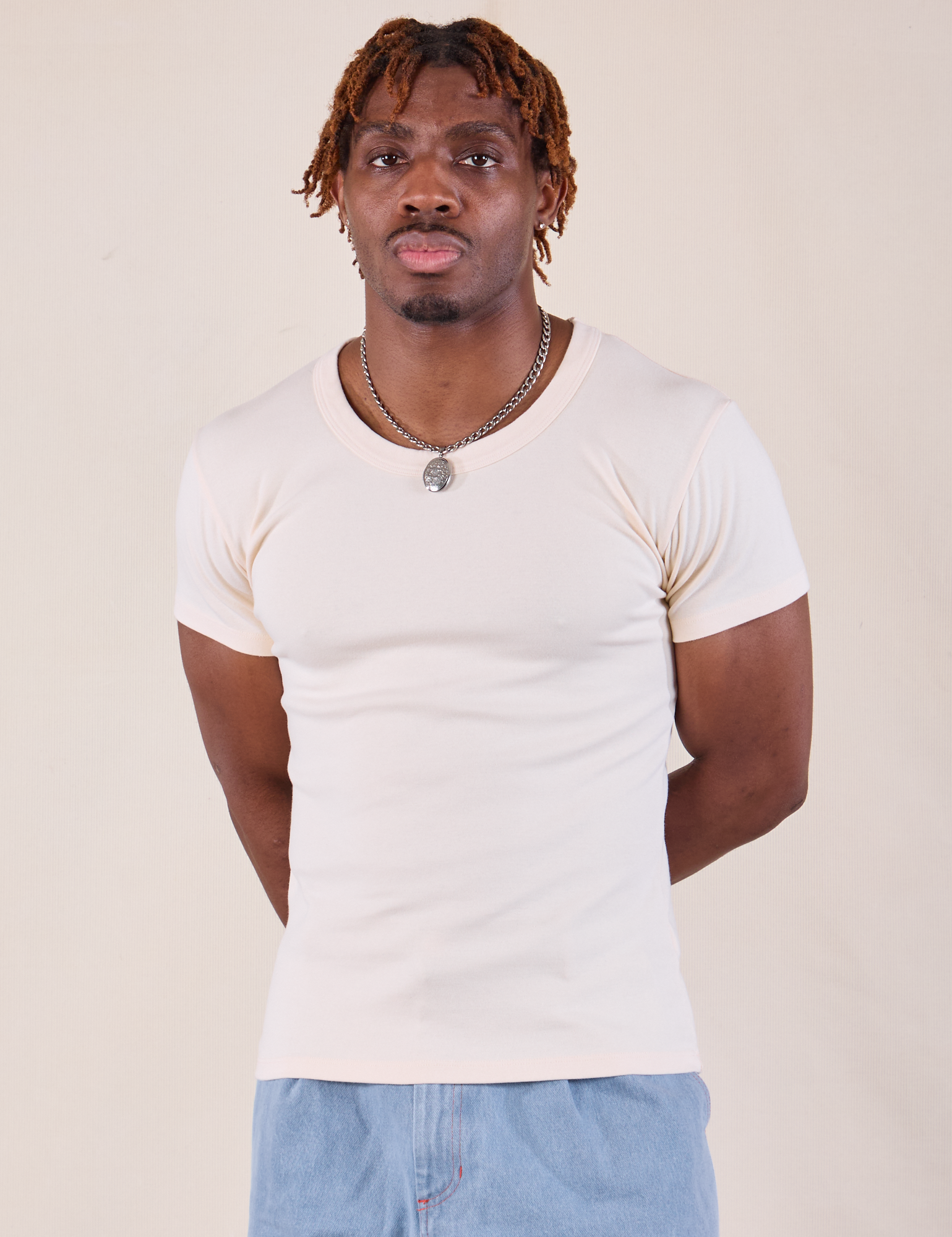 Isaac is 5'10" and wearing L Baby Tee in Vintage Tee Off-White