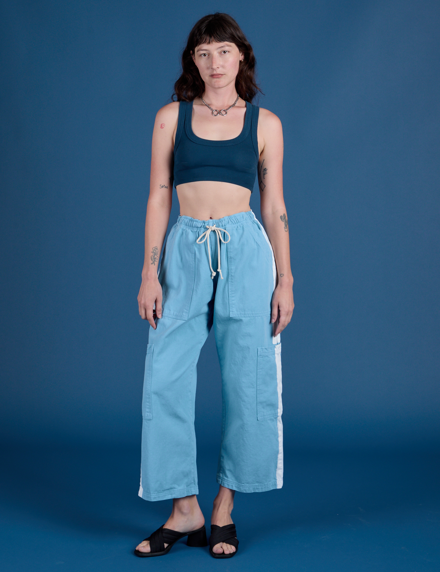 Alex is wearing Painted Drop Pocket Cargo Pants in Baby Blue and Mini Tank in Lagoon