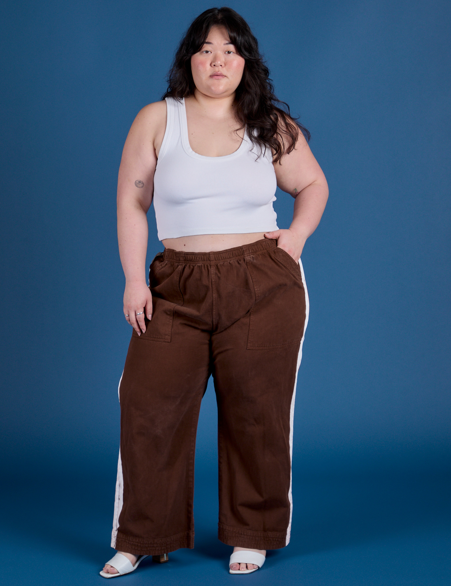 Ashley is wearing Painted Action Pants in Fudgesicle Brown and Cropped Tank in Vintage Tee White
