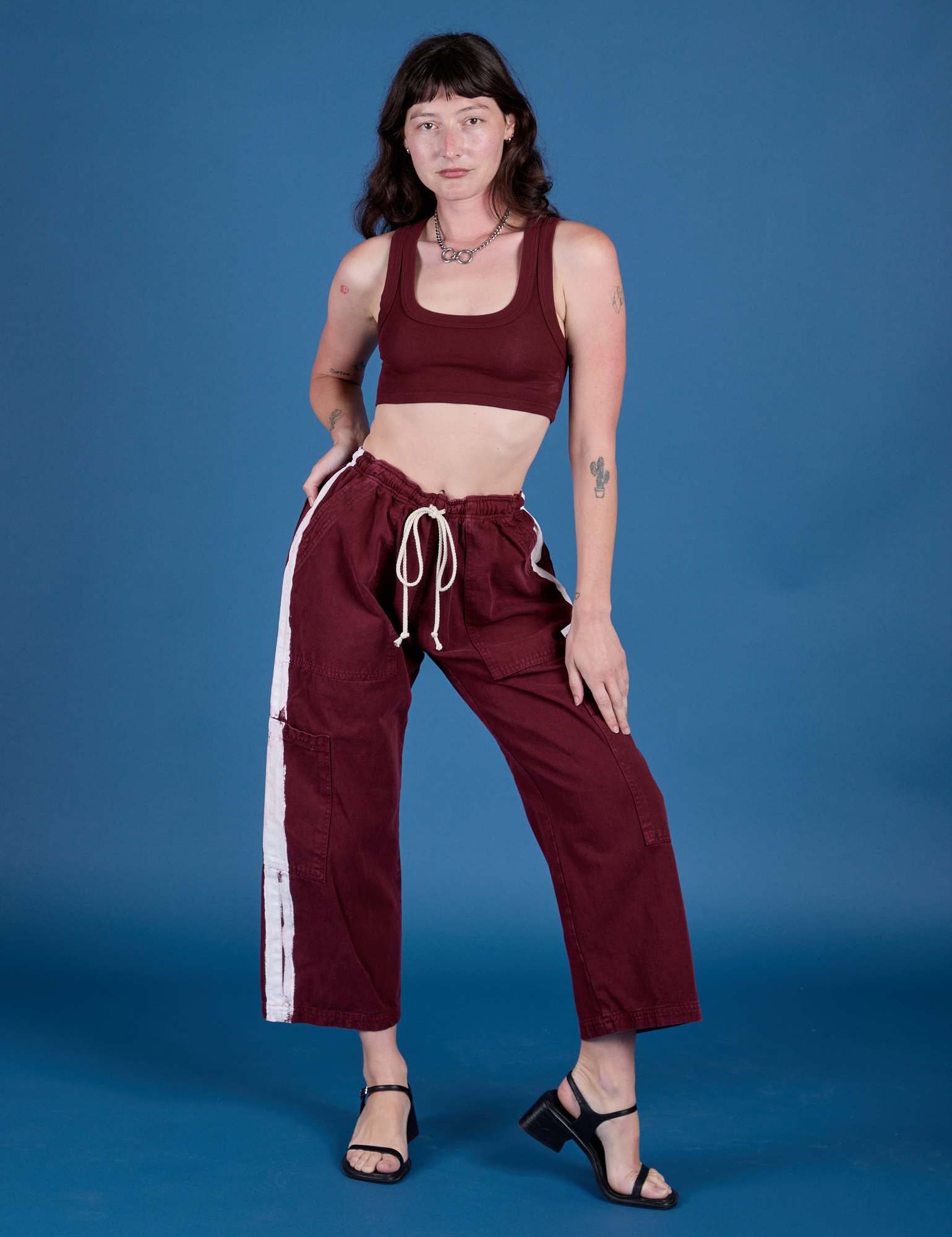 Alex is wearing Painted Drop Pocket Cargo Pants in Red Wine and matching Mini Tank