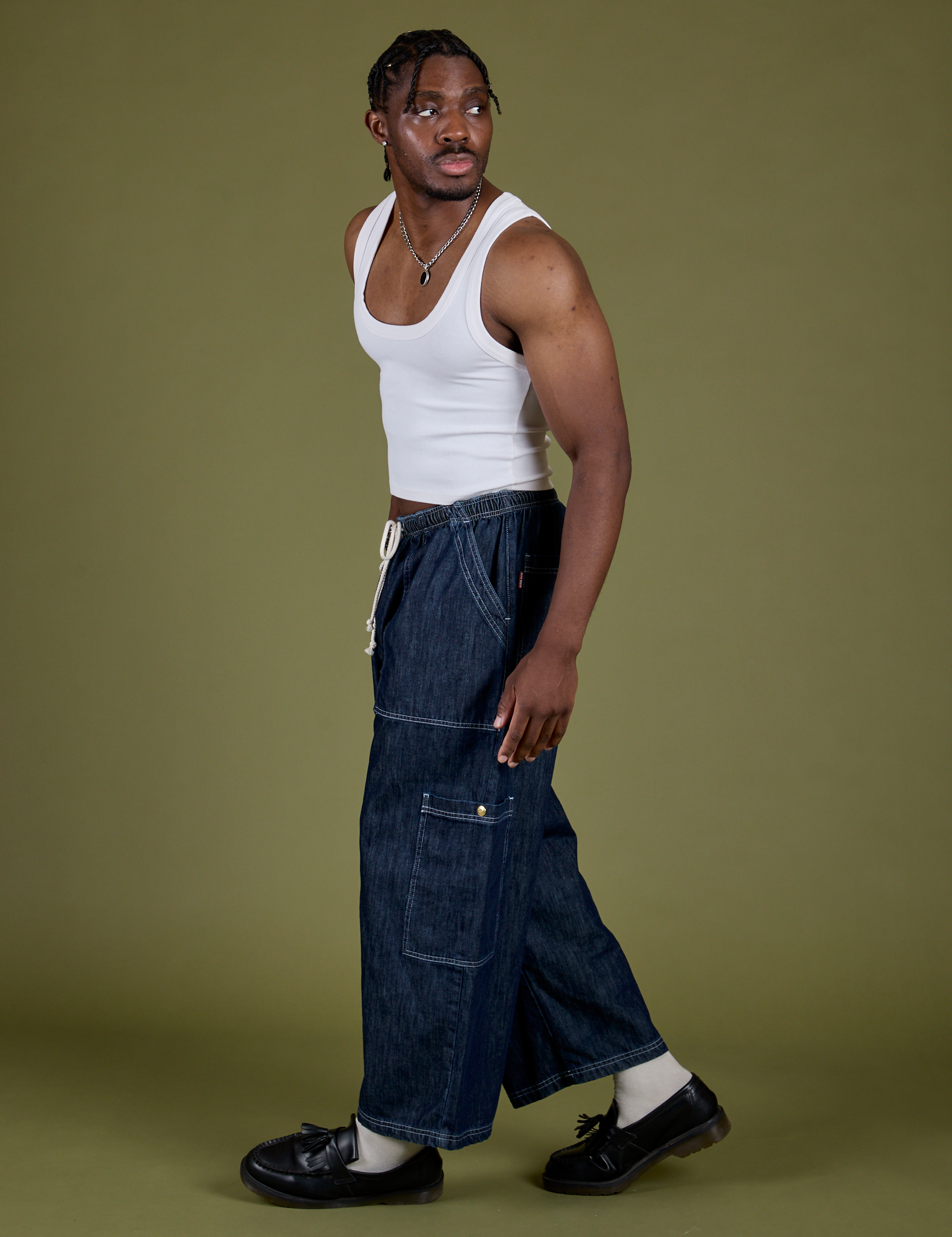Side view of Denim Drop Pocket Pants in Dark Wash and Cropped Tank in Vintage Tee White on Isaac