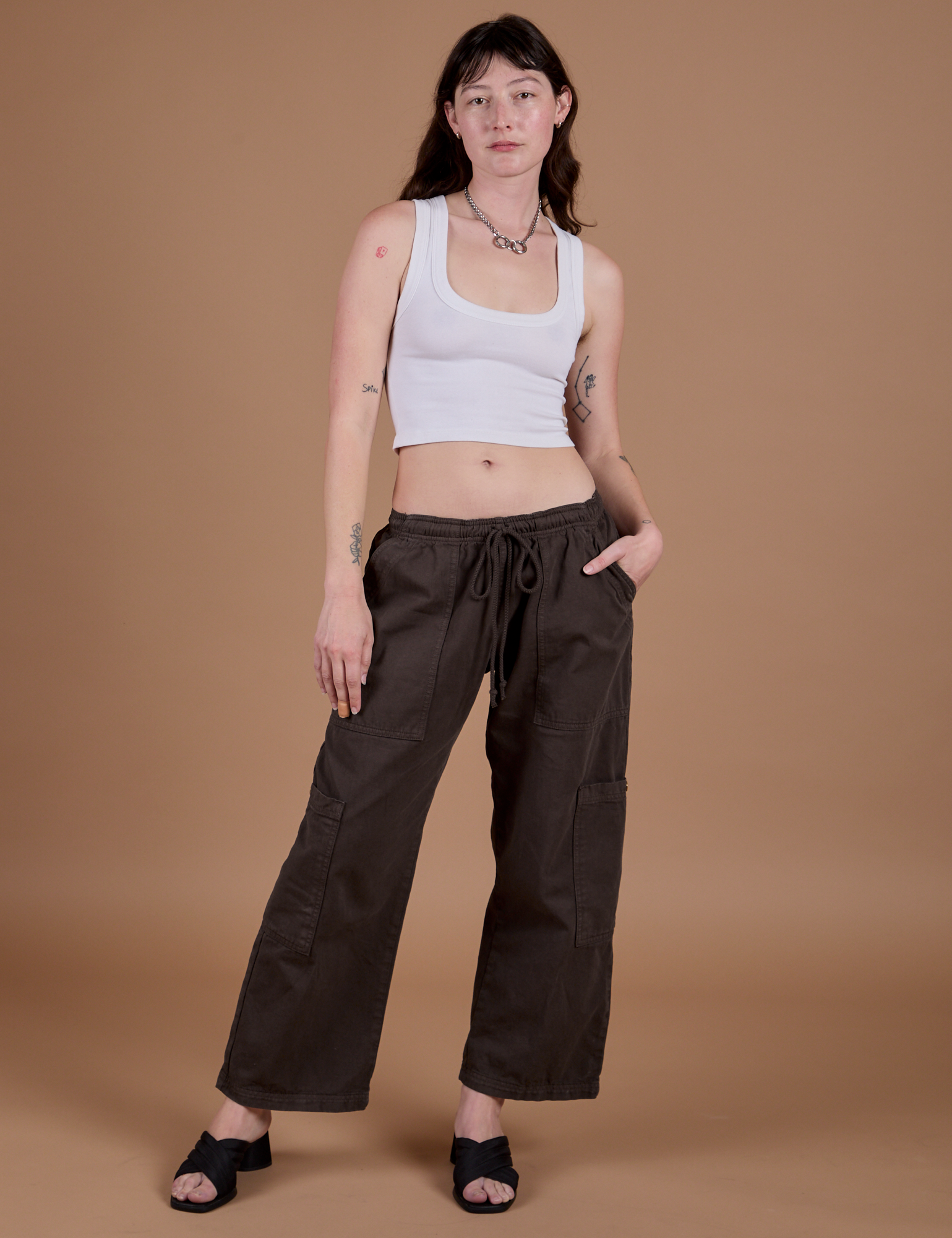 Alex is wearing Drop Pocket Cargo Pants in Espresso Brown and Cropped Tank in Vintage Tee White