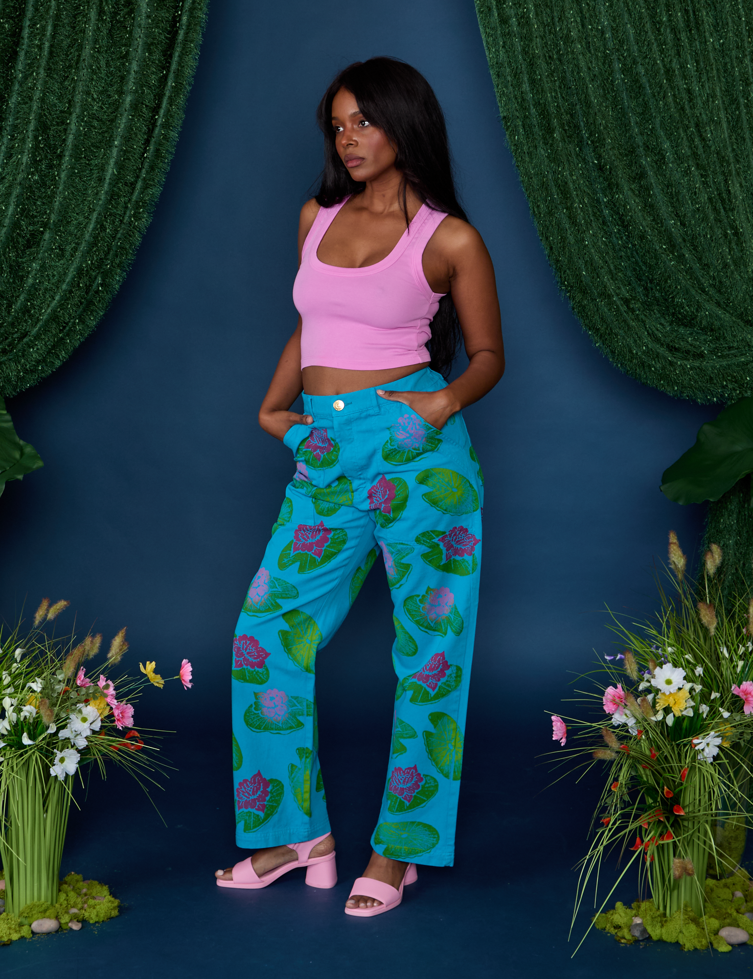 Angled front view of Paintstamped Work Pants in Lilypad and bubblegum Cropped Tank on Kandia