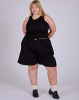 Juliet is wearing Pleated Trouser Shorts in Basic Black and Racerback Tank in Black