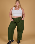 Juliet is wearing Baggy Mid-Rise Trousers in Evergreen and vintage tee white Cropped Tank