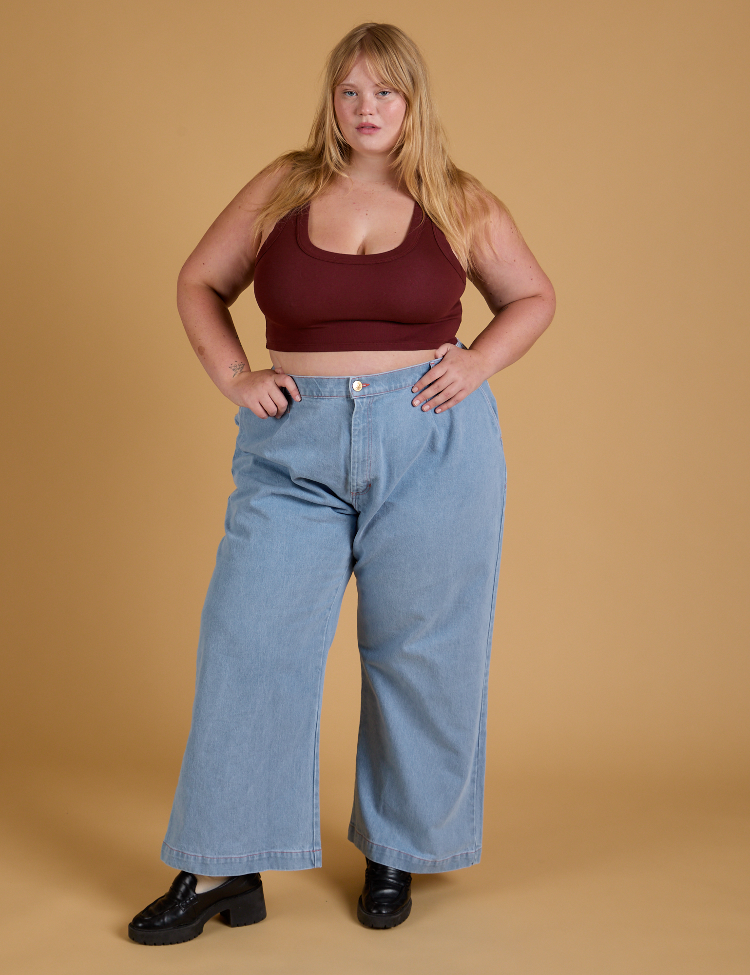 Juliet is wearing Mini Tank in Red Wine and light wash Indigo Wide Leg Trousers