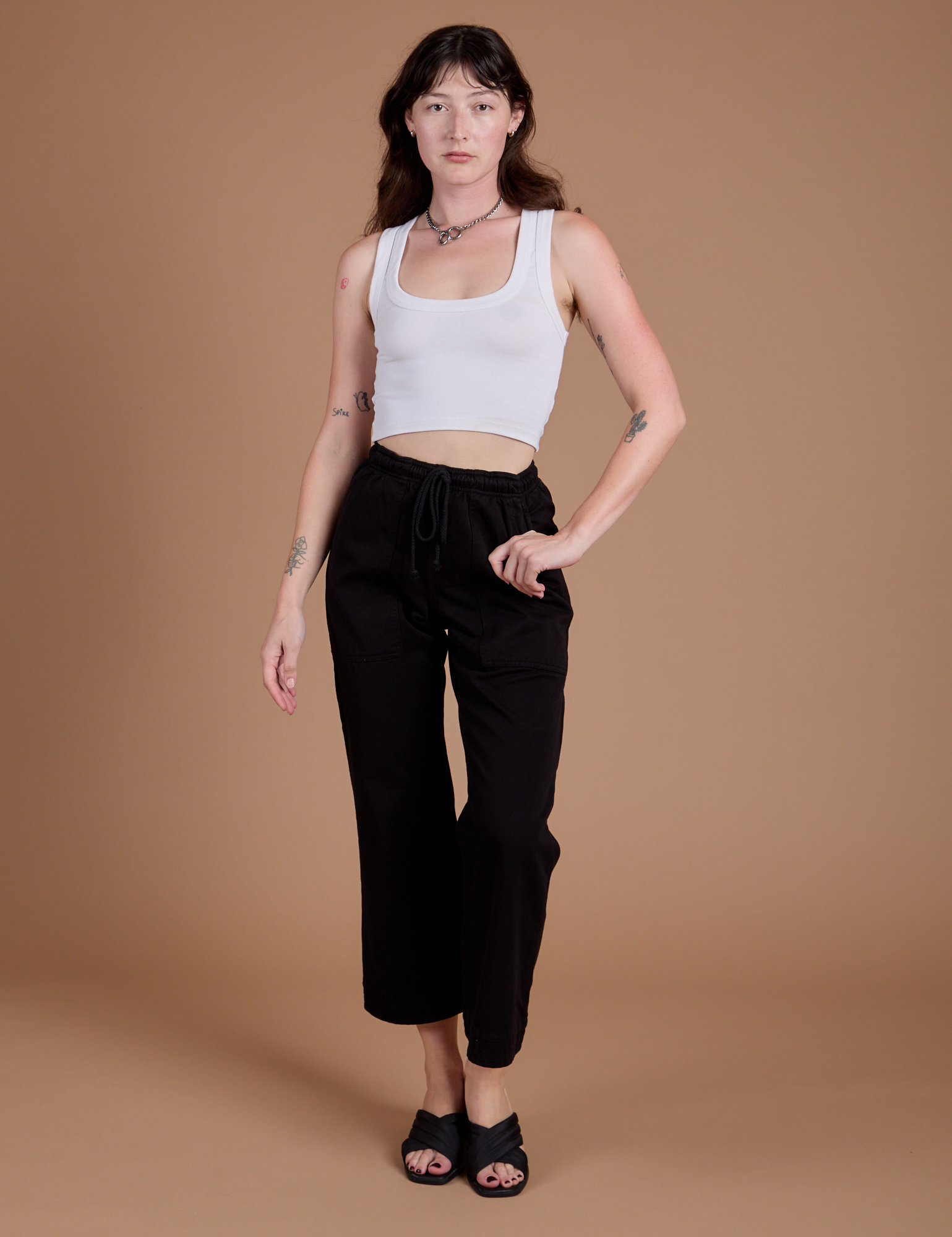 Alex is wearing Organic Action Pants in Basic Black and vintage tee white Cropped Tank