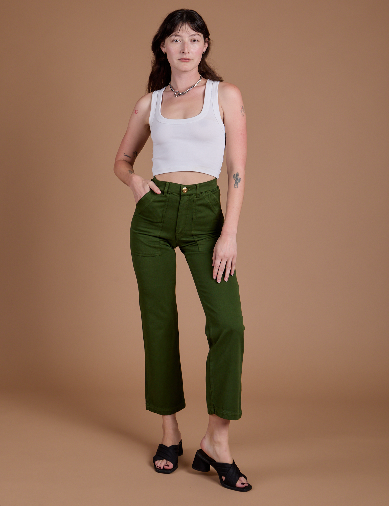 Alex is wearing Organic Work Pants in Evergreen and vintage tee white Cropped Tank