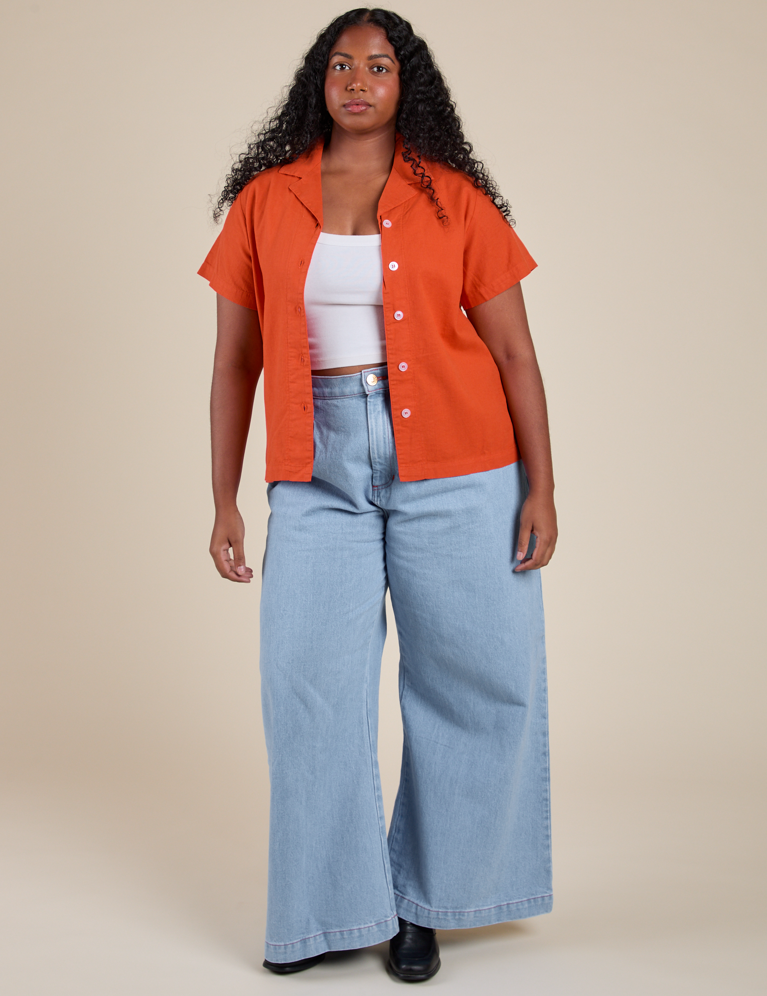 Meghna is wearing Pantry Button-Up in Chili Red and light wash Indigo Wide Leg Trousers