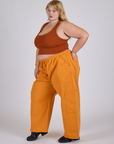 Side view of Drop Pocket Cargo Pants in Creamsicle Orange and burnt terracotta Cropped Tank on Juliet