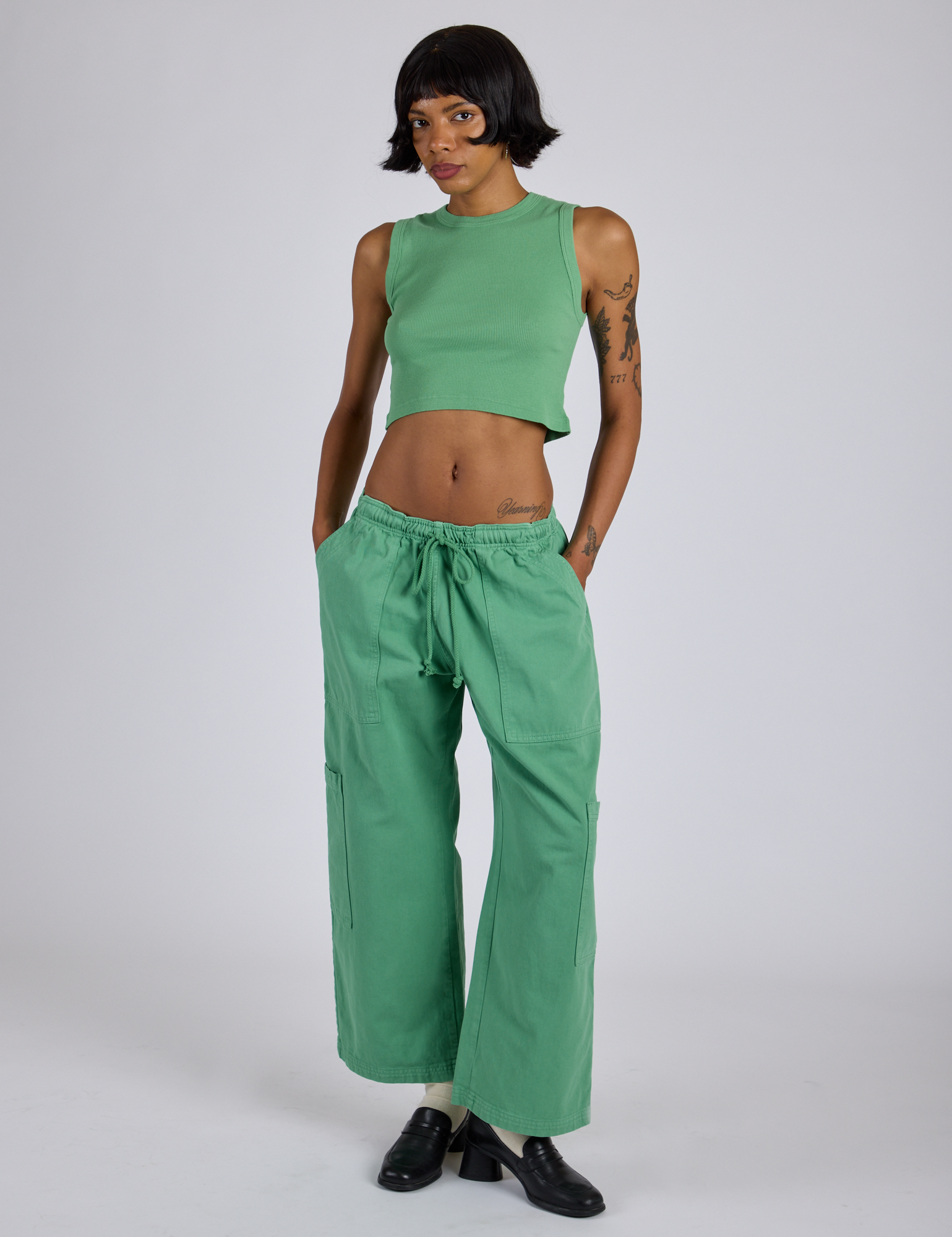 Kira is wearing Drop Pocket Cargo Pants in Seafoam Green and matching Muscle Tee