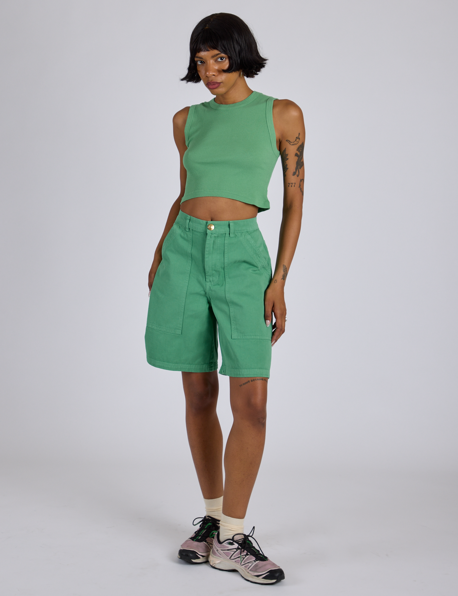 Kira is wearing Longline Work Shorts in Seafoam Green and matching muscle tee