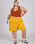 Juliet is wearing Longline Work Shorts in Sunshine Yellow and burnt terracotta Cropped Tank