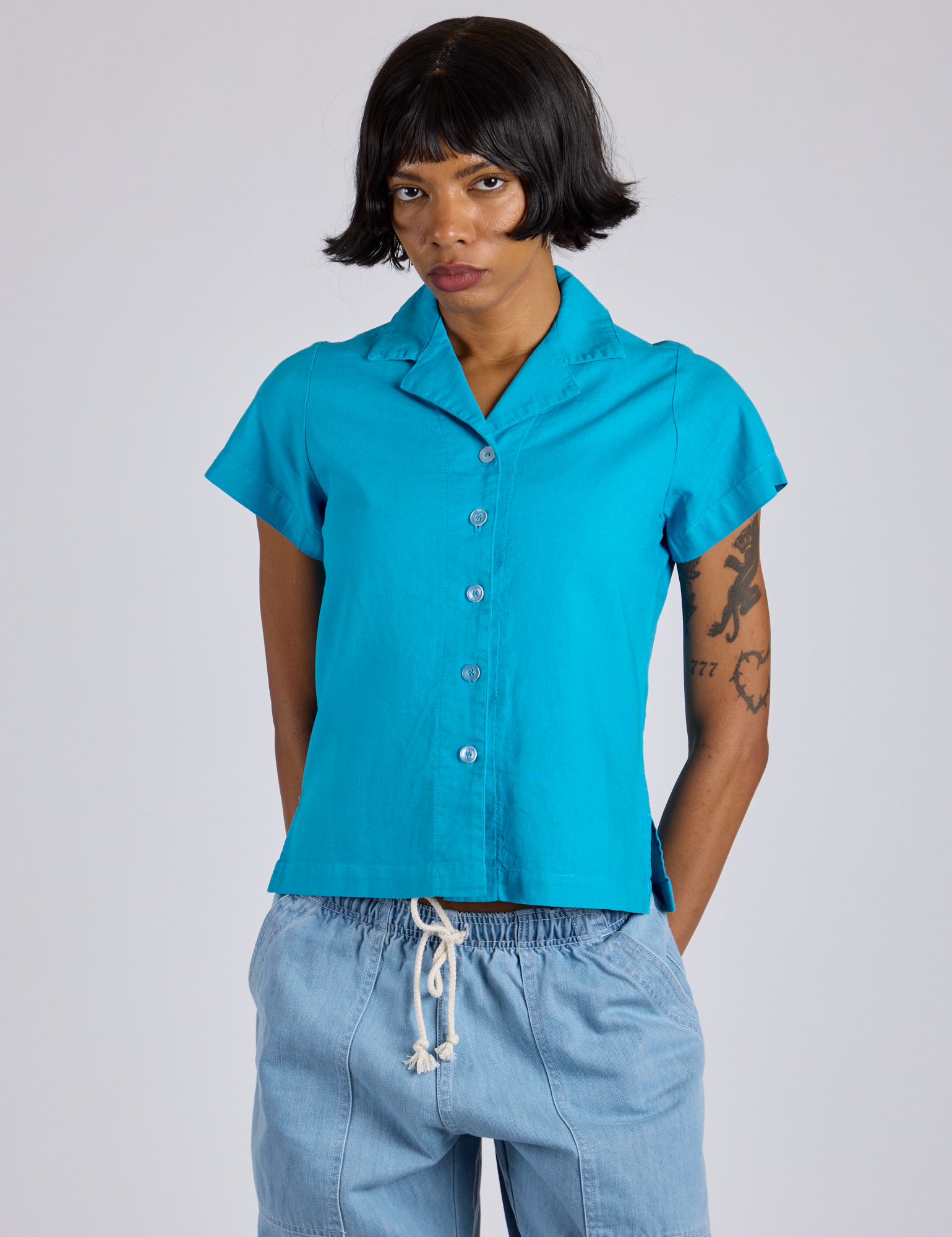 Kira is wearing a buttoned up Pantry Button-Up in Hawaiian Blue