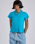 Kira is wearing a buttoned up Pantry Button-Up in Hawaiian Blue