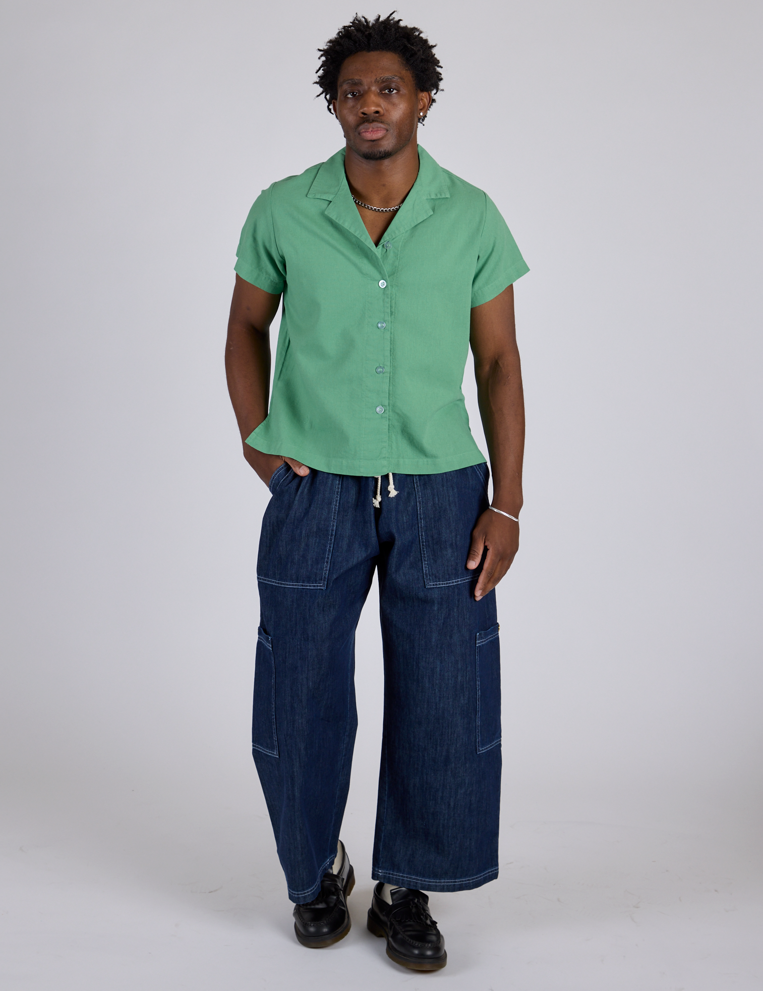 Isaac is wearing Pantry Button-Up in Seafoam Green and dark wash Denim Drop Pocket Pants