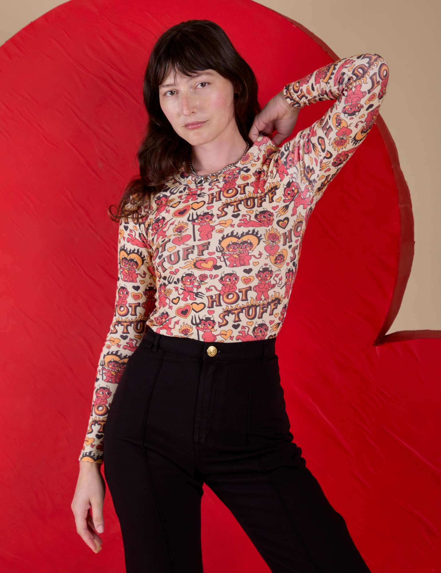 Alex is wearing Long Sleeve Baby Tee in Hot Stuff Print tucked into black Western Pants