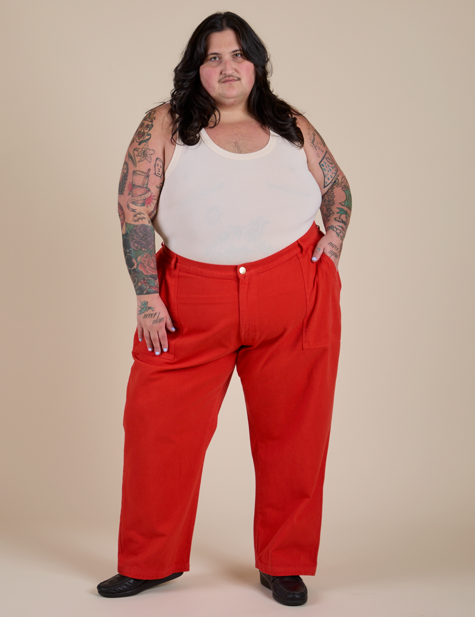 Sam is wearing Work Pants in Mustang Red and vintage tee white Cropped Tank