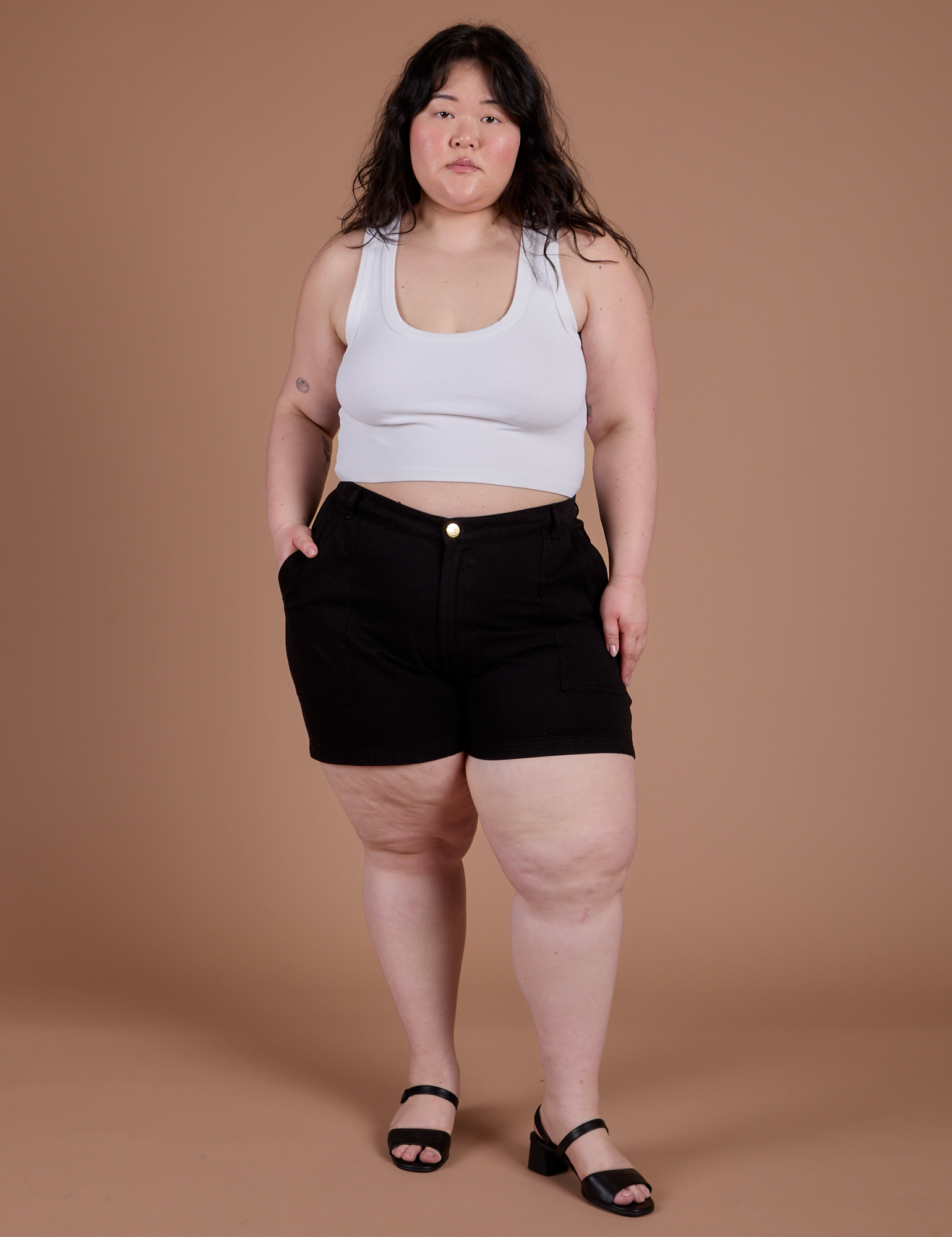 Ashley is wearing Classic Work Shorts in Basic Black and a Cropped Tank in Vintage Tee White
