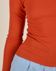  Long Sleeve Baby Tee in Chili Red bottom close up on Alex