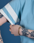 Painted Burly Tee in Baby Blue close up of sleeve with two painted white stripes