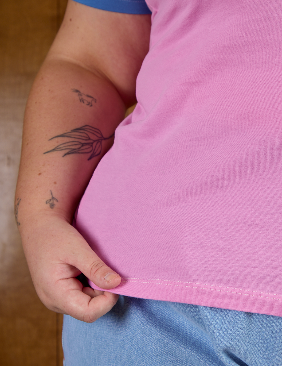 Close up of Juliet holding the bottom hem of Calypso Tee in Bubblegum Multi