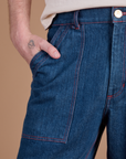 Close up of Quinn's hand in the front pocket of Carpenter Jeans in Dark Wash