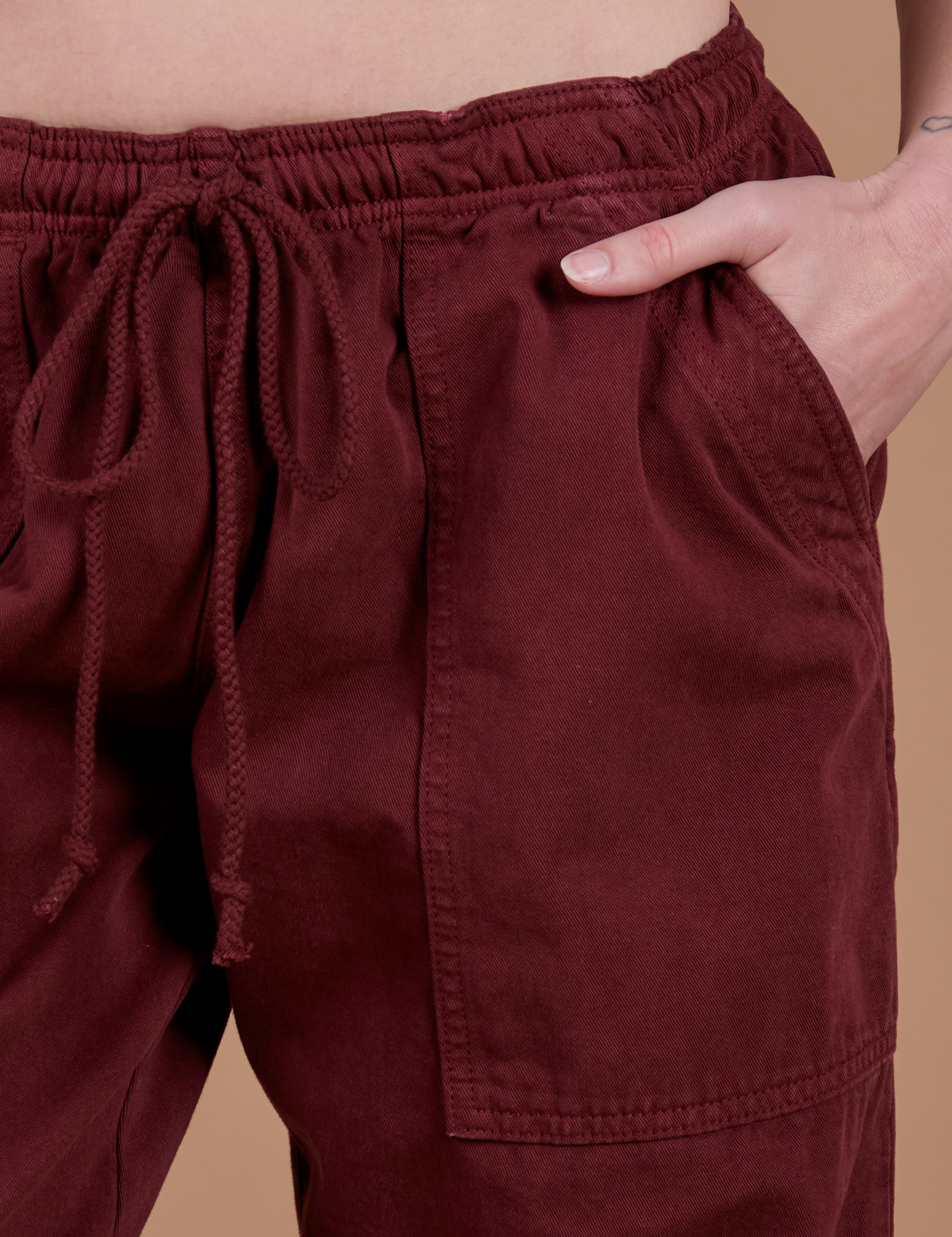 Close up of Alex's hand in the front pocket of Drop Pocket Cargo Pants in Red Wine
