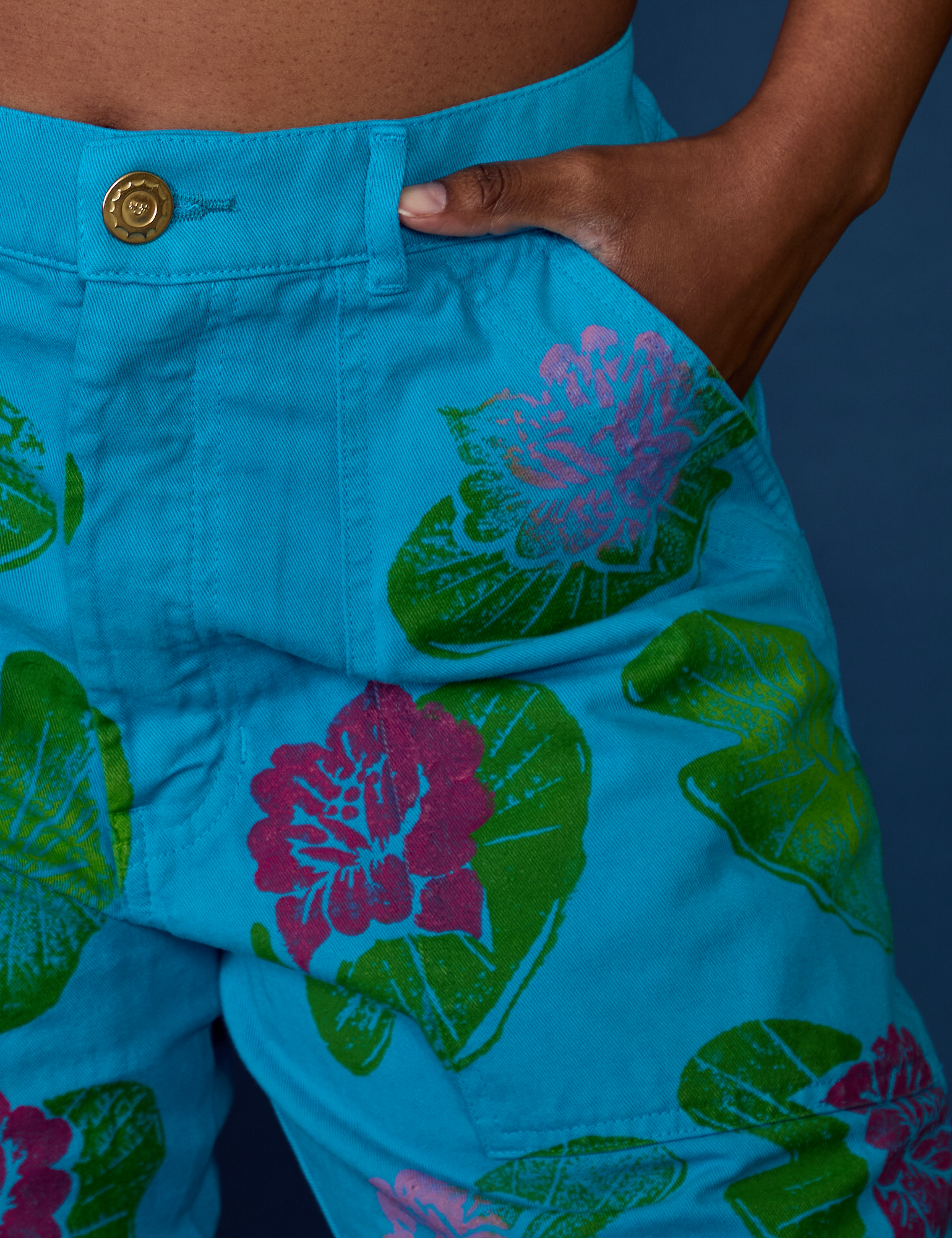 Close up of Kandia's hand in the front pocket of Paintstamped Work Pants in Lilypad