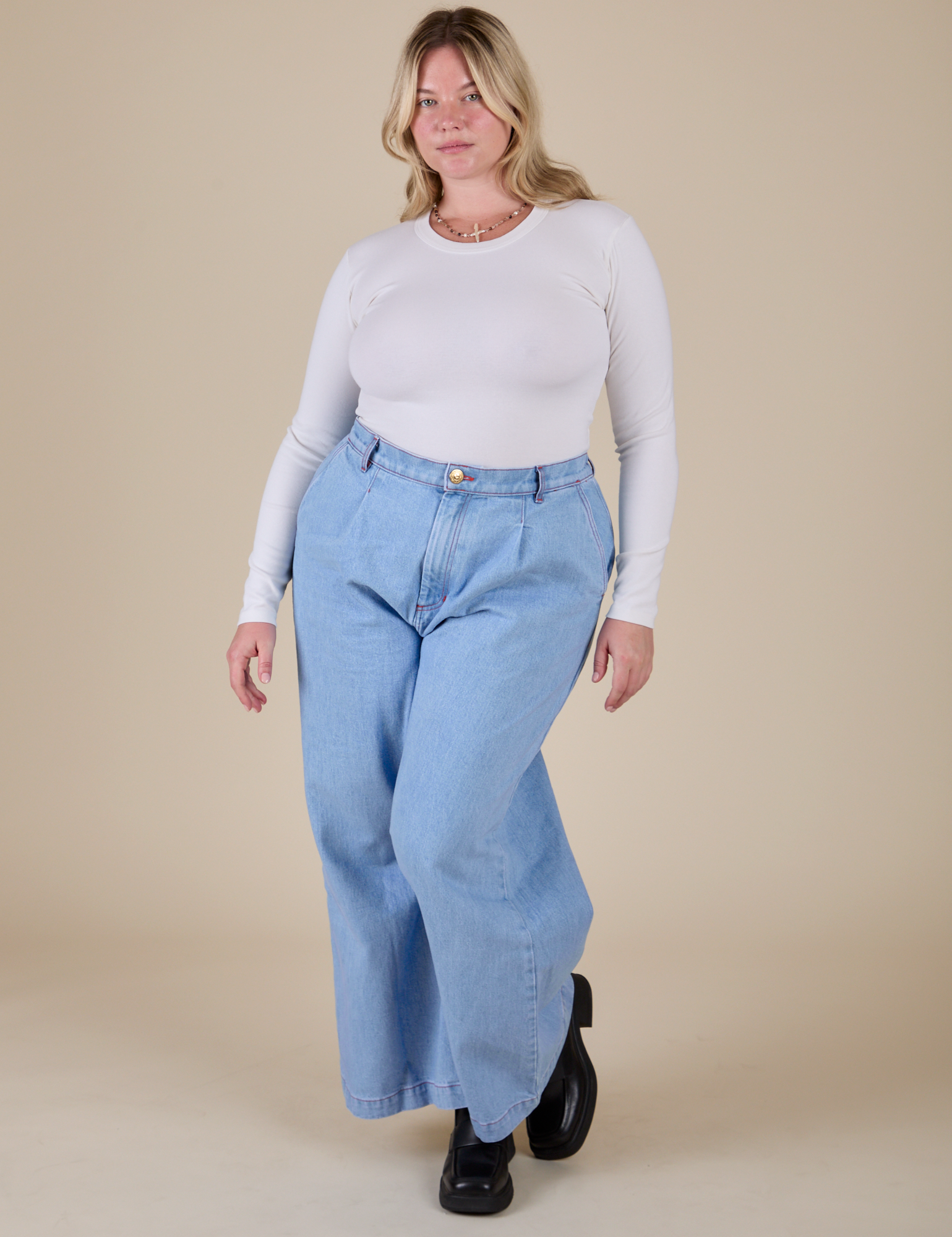 Lish is wearing Long Sleeve Baby Tee in Vintage Tee Off-White and light wash Indigo Wide Leg Trousers