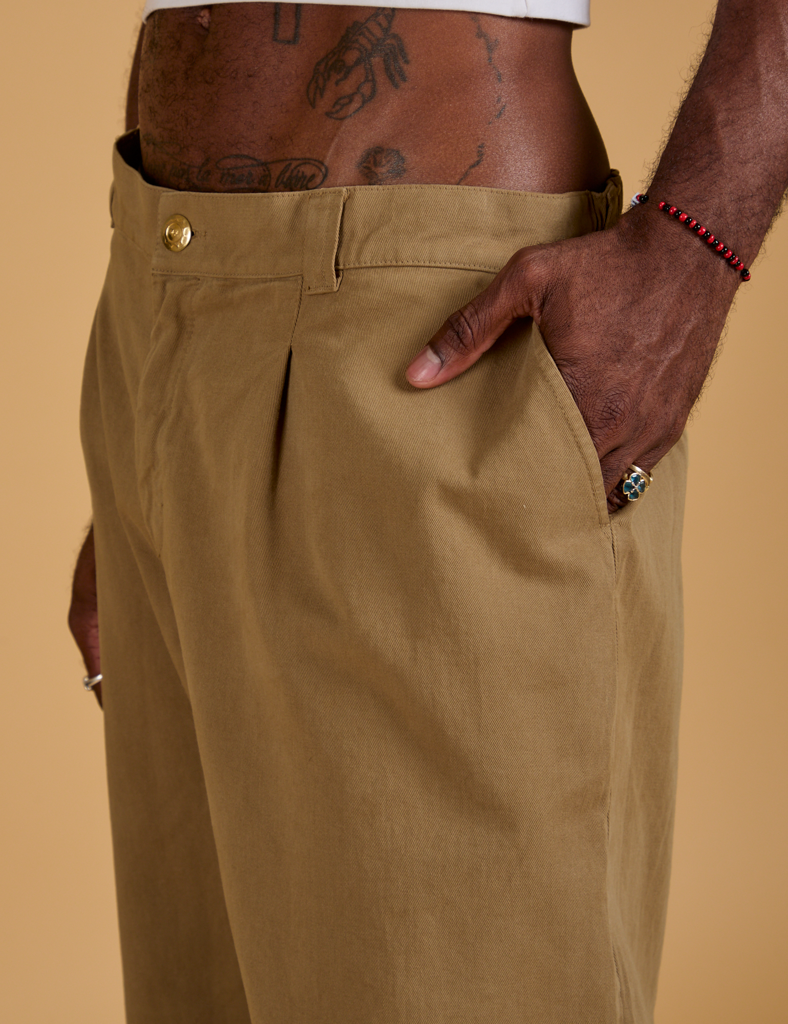 Close up of Jerrod's hand in the front pocket of Baggy Mid-Rise Trousers in Desert Brown