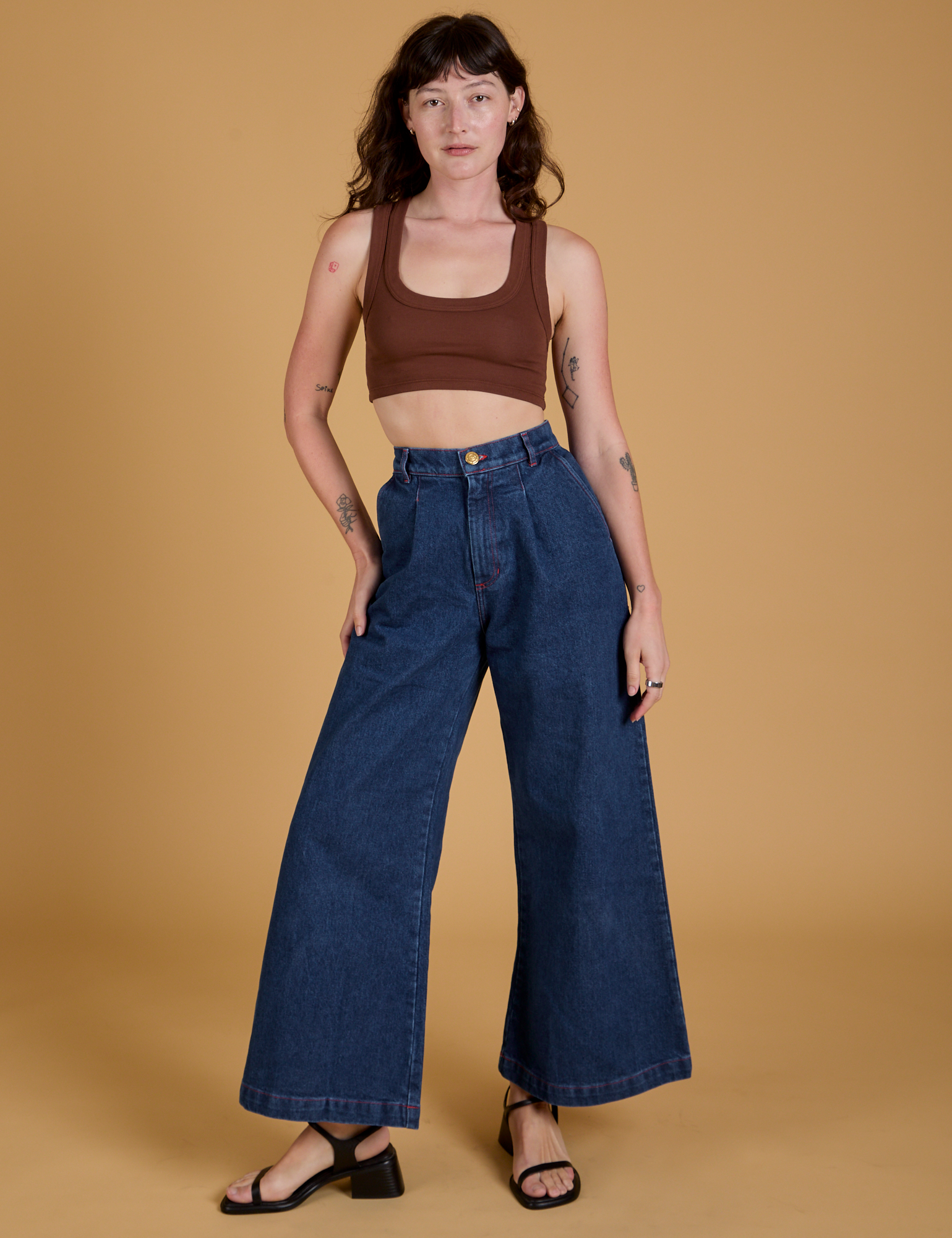 Alex is wearing Mini Tank in Fudgesicle Brown and dark wash Indigo Wide Leg Trousers
