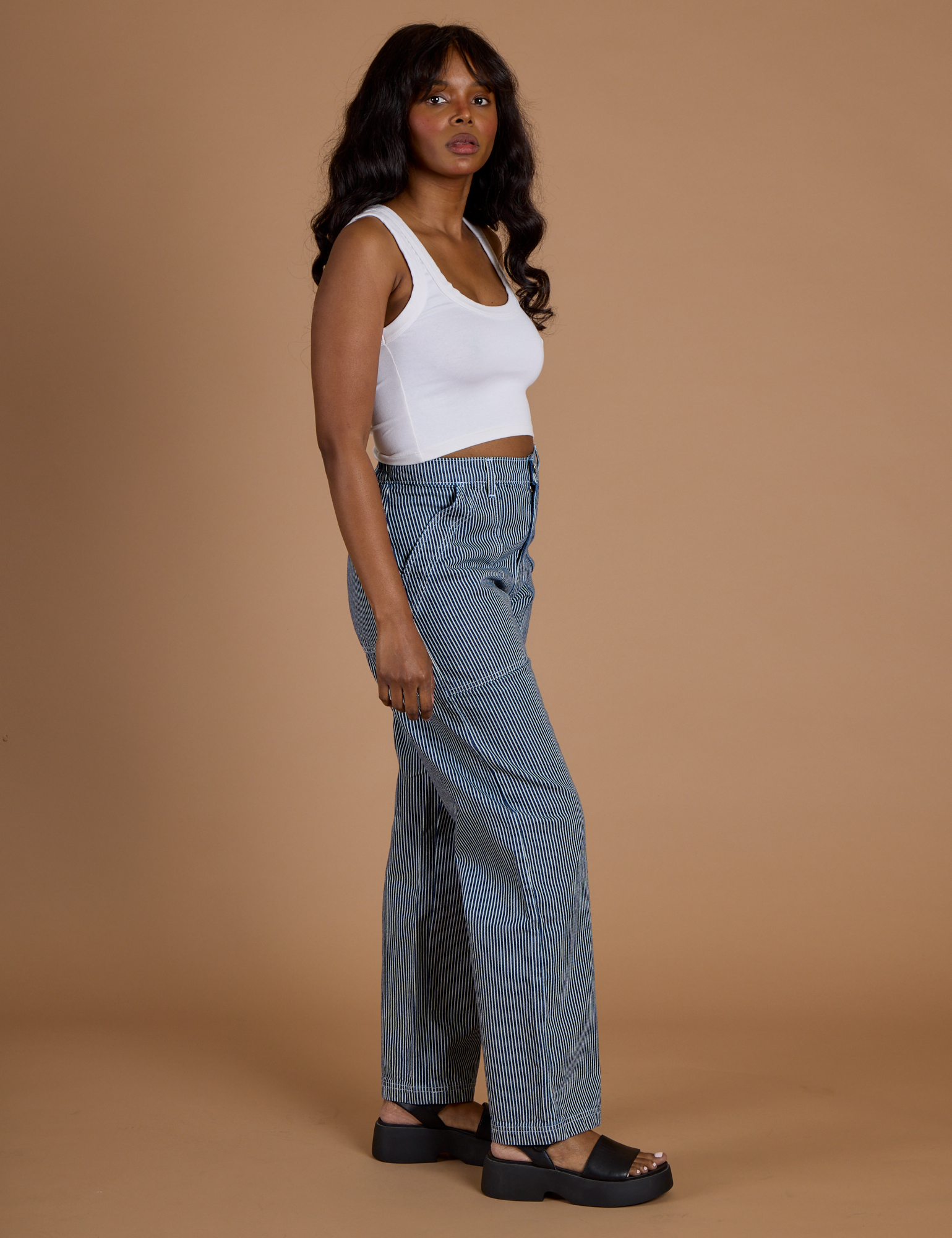 Side view of Railroad Denim Work Pants in Natural and vintage tee white Cropped Tank on Kandia