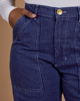 Close up of Kandia's hand in the front pocket of Railroad Denim Work Pants in Faded Grape Overdye