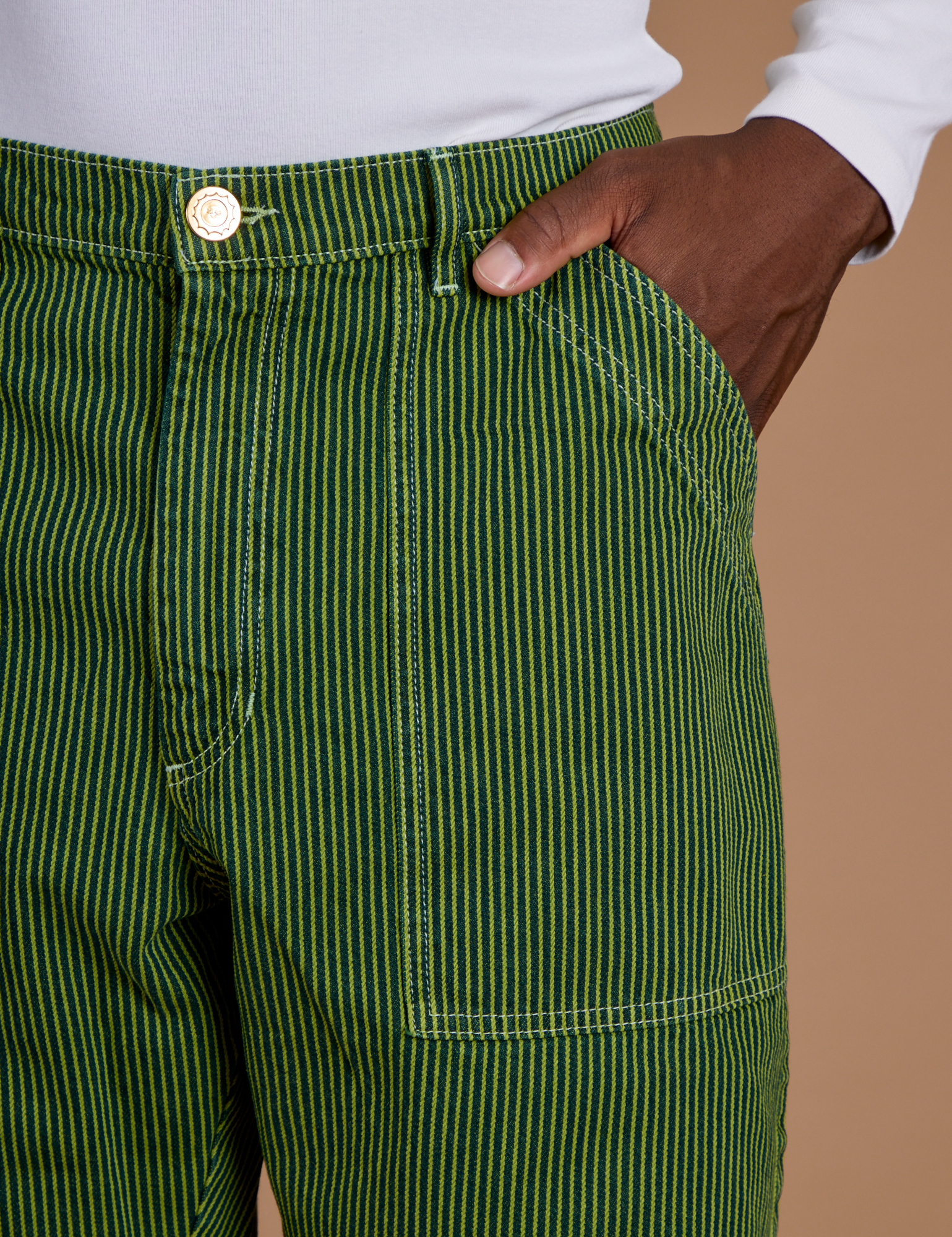 Close up of Isaac's hand in the front pocket of Railroad Denim Work Pants in Gross Green Overdye