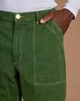 Close up of Isaac's hand in the front pocket of Railroad Denim Work Pants in Gross Green Overdye
