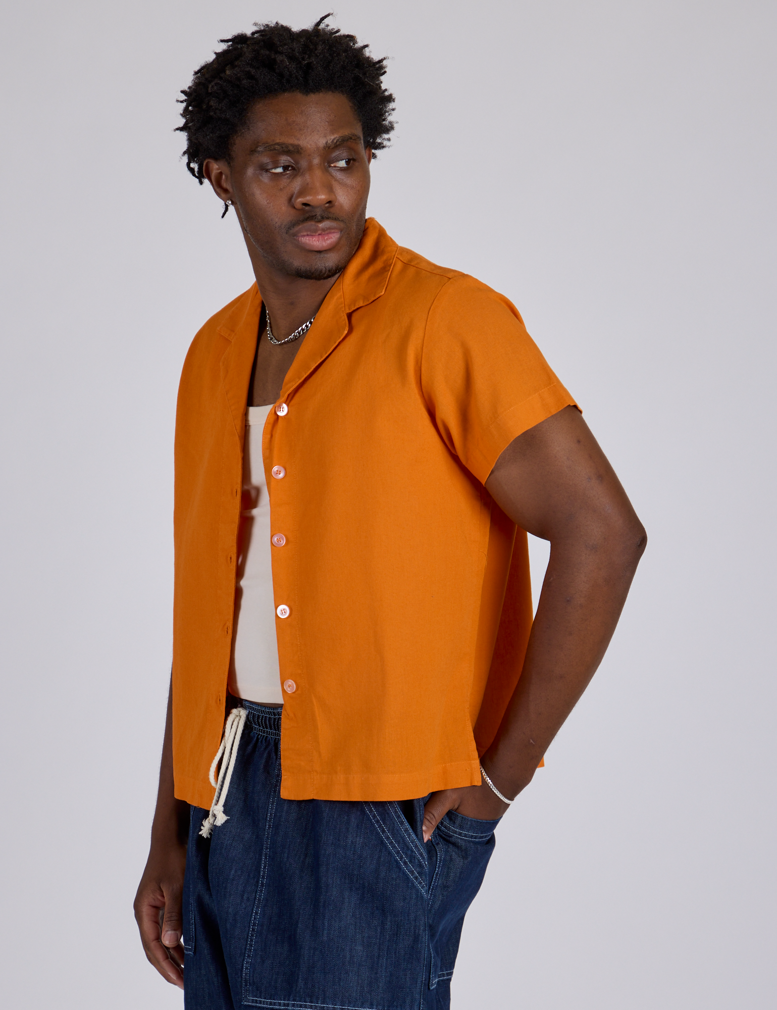 Angled front view of Pantry Button-Up in Creamsicle Orange on Isaac