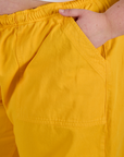 Close up of Juliet's hand in the front pocket of Drop Pocket Cargo Pants in Sunshine Yellow