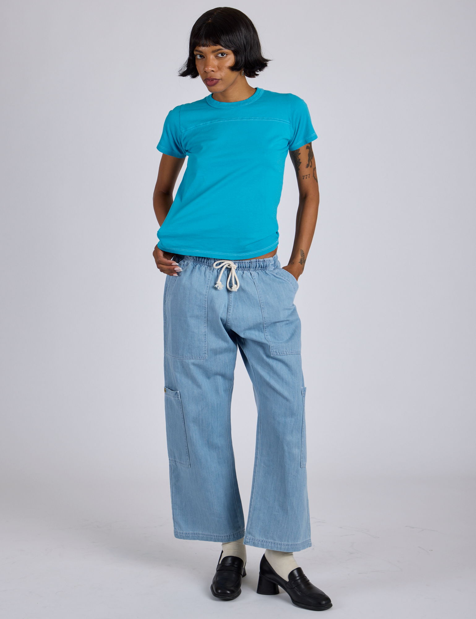 Kira is wearing Jr. Varsity Tee in Hawaiian Blue and light wash Denim Drop Pocket Pants