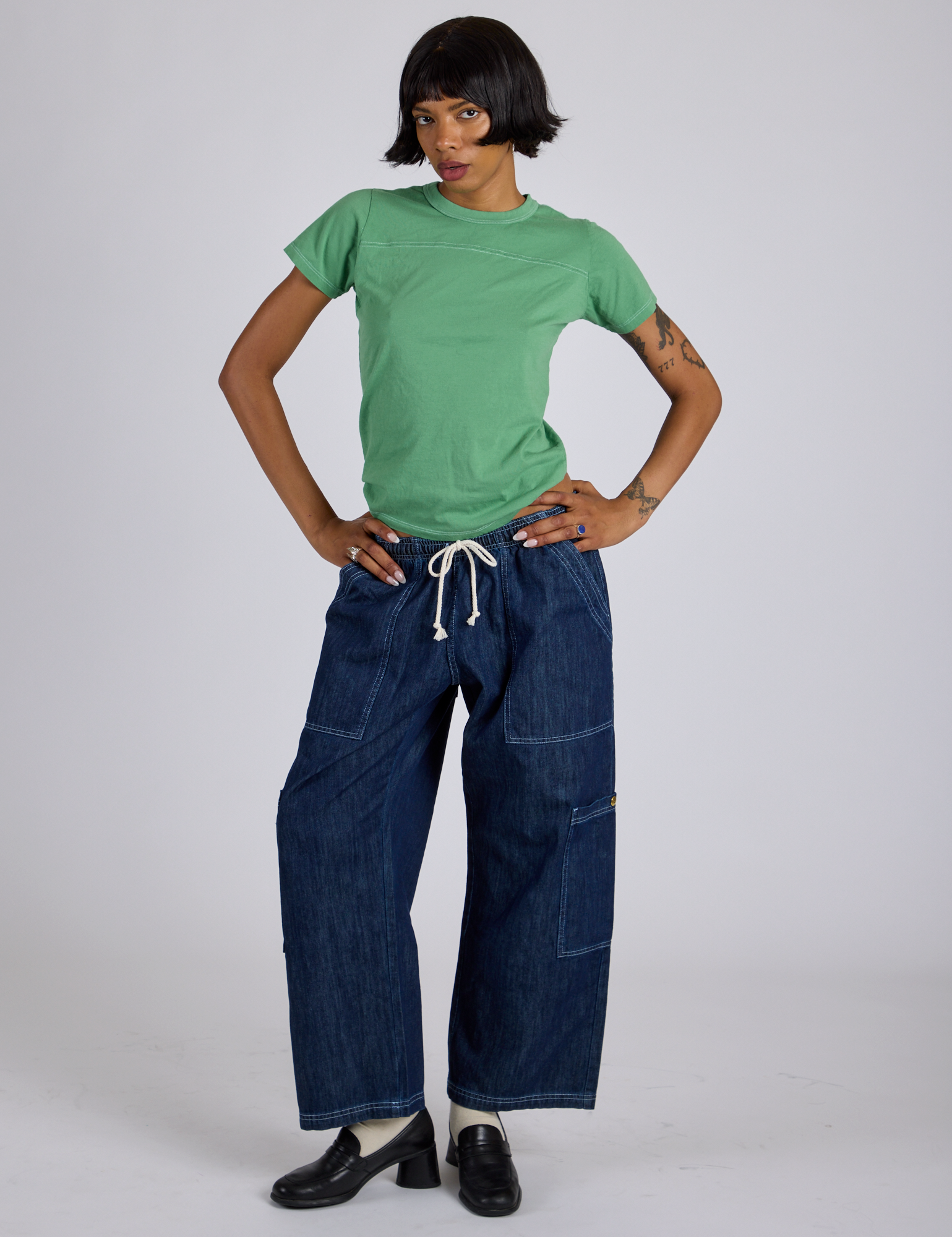 Kira is wearing Jr. Varsity Tee in Seafoam Green and dark wash Denim Drop Pocket Pants