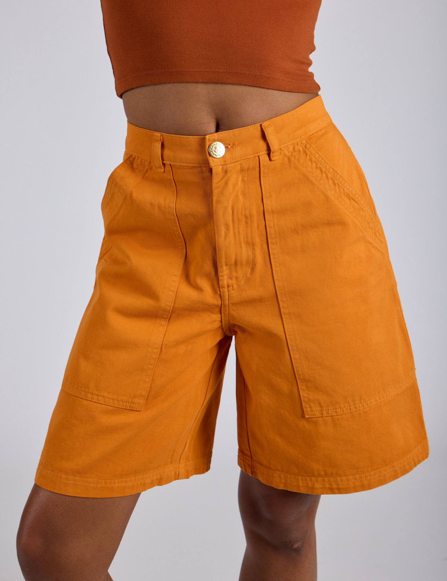 Longline Work Shorts in Creamsicle Orange close up on Kira