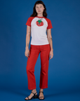 Alex is wearing Produce Raglan Tee in Tomato and mustang red work pants