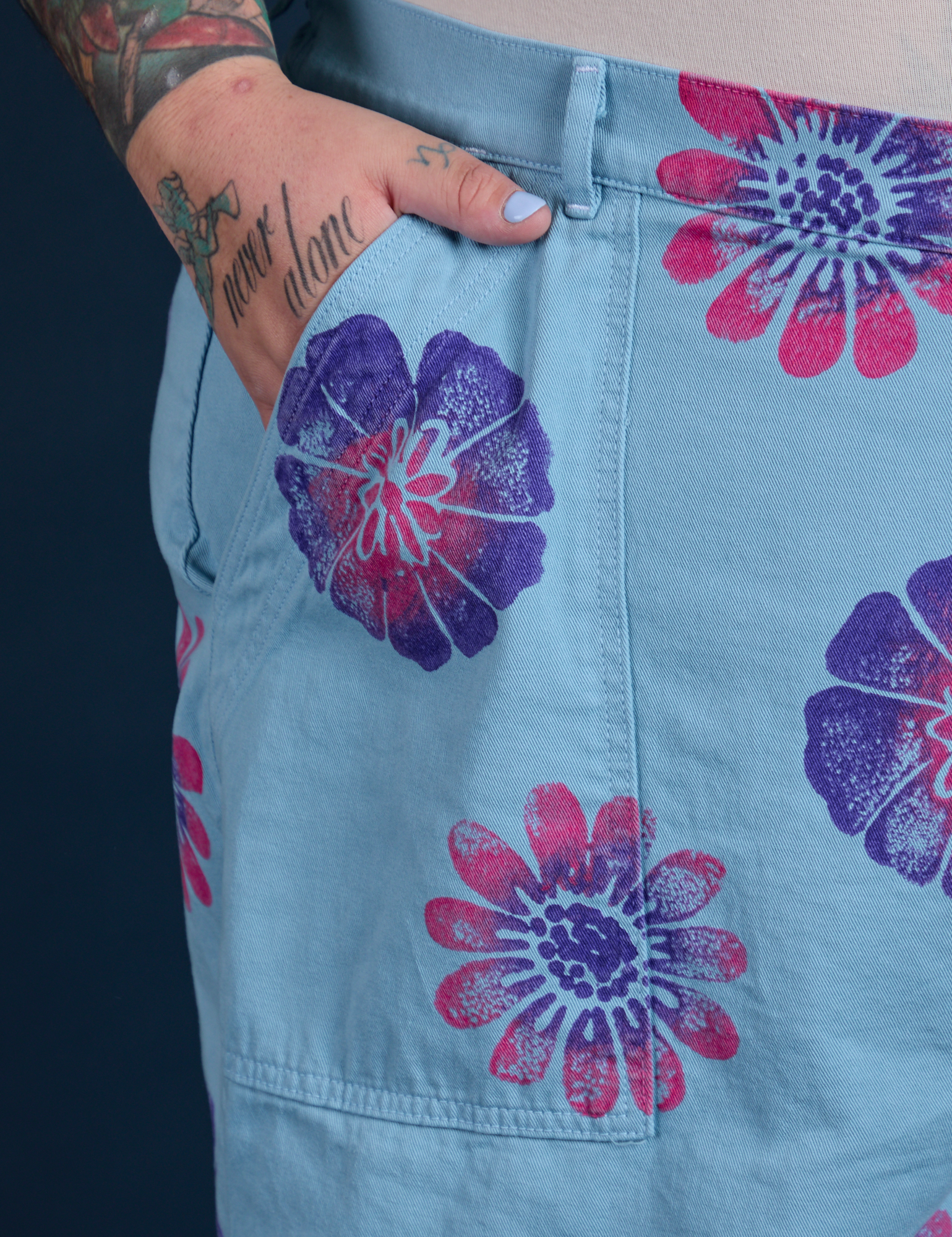 Close up of Sam's hand in the front pocket of Floral Painted Work Pants in Blue